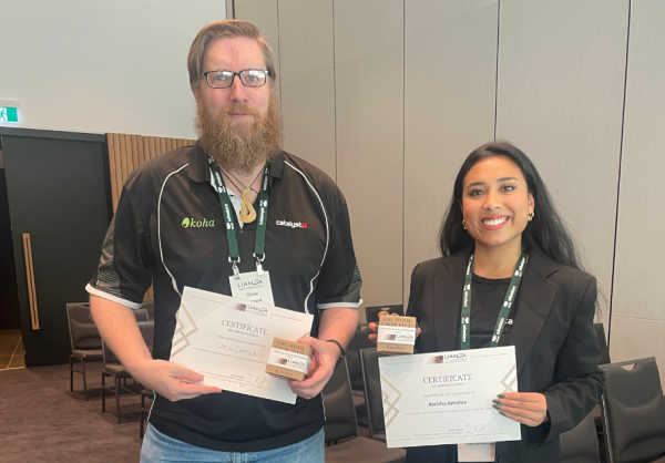 Chris Cormack and Aleisha Amohia holding their speaker certificates and gifts after presenting