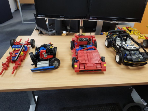 Several complete car lego sets laid out on a table