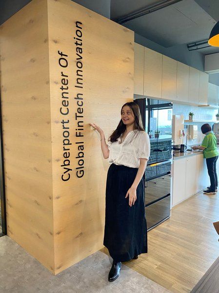 Wainui standing next to a sign for Cyberport Center of Global FinTech Innovation.