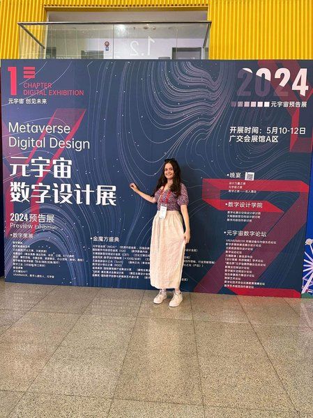 Wainui stands in front of a large sign at the ARVR fair in China.