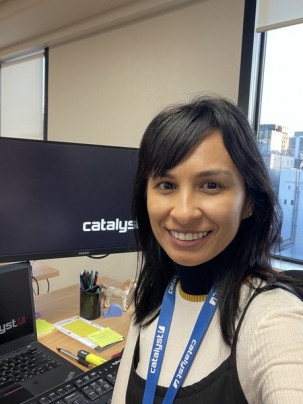 Haajar Pengelly sitting in front of a computer with the Catalyst logo