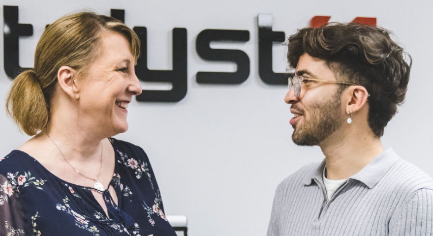 Two people smiling while talking about the content on a tablet device